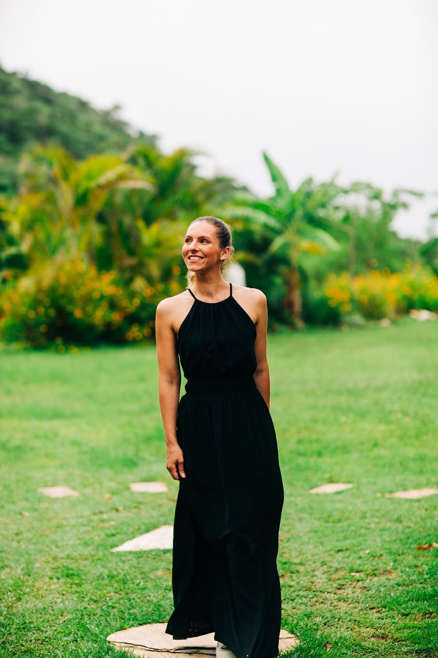 Renata Hermes sorrindo, de vestido preto, em um jardim