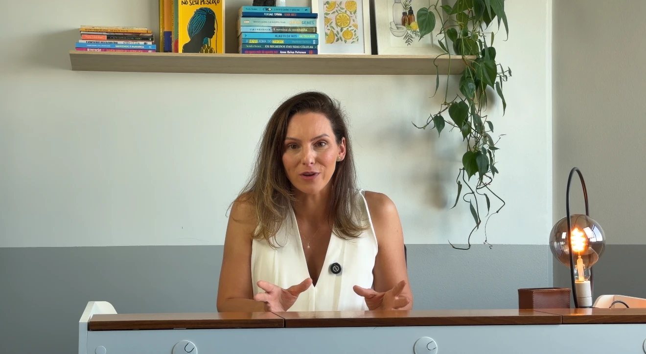 Renata Hermes falando para a câmera em seu escritório